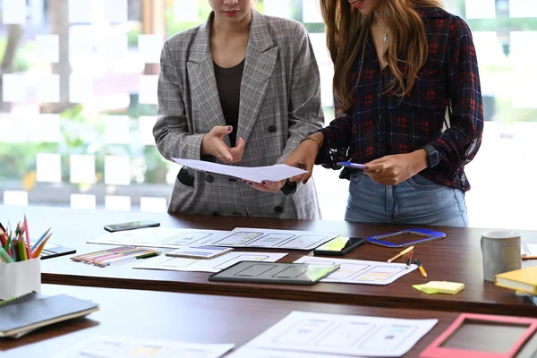 Två unga kvinnliga designer brainstorming och diskutera för mobila program design projekt. — Stockfoto
