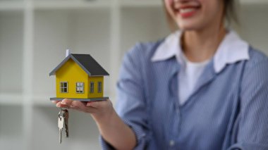 Ev modeli ve anahtarları olan bir emlakçı. Yeni ev, sigorta ve emlak konsepti
