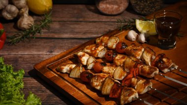 Çeri domatesli ızgara tavuk kebabı, tatlı biber ve ahşap tabakta soğan. BBQ, yemek, parti konsepti