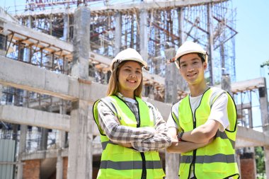 İnşaat alanında kolları çapraz duran miğfer takan mimar ve inşaat mühendisi. Endüstri, Mühendis, inşaat konsepti