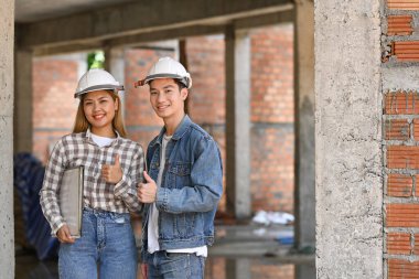 İnşaat alanında duran kasklı iki genç mühendis. Endüstri, Mühendis, inşaat konsepti