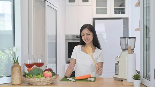 Alegre asiático de pé no balcão de cozinha moderna e preparar ingrediente para fazer comida vegetariana — Fotografia de Stock