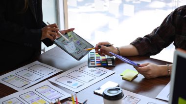 Mobil uygulama arayüzü kablo tasarımı hakkında beyin fırtınası yapan ve planlayan web sitesi geliştirici ekibi.