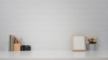 Kamera, çerçeve ve tuğla duvarın karşısında saksısı olan yaratıcı bir iş yeri. Reklam metniniz için alanı kopyalayın.