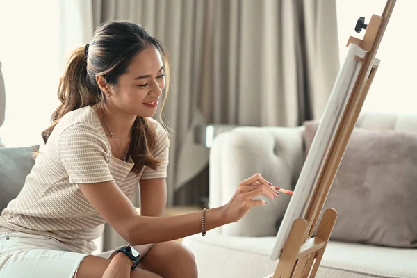 Charmante jeune femme peinture tableau sur toile avec des peintures à l'huile à la maison. — Photo