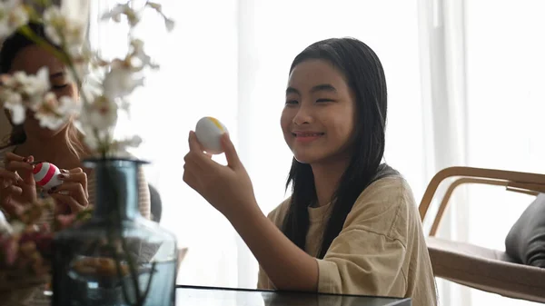 Szczęśliwa dziewczynka trzyma jajko, przygotowując się do Szczęśliwego Dnia Wielkanocnego. — Zdjęcie stockowe
