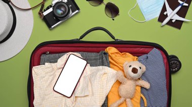 Bir çanta dolusu kıyafet, kamera, güneş gözlüğü, pasaport ve yaz tatili için şapka. Üst görünüm