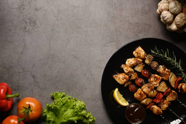 黒石の背景に新鮮な野菜と鶏の肉串焼き。テキストのスペースをコピー — ストック写真