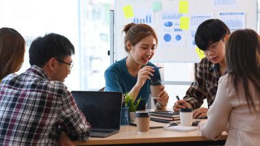 Girişim ekibi, modern ofiste birlikte yeni bir başlangıç projesi üzerinde kafa yoruyor ve tartışıyorlar..