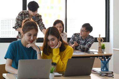 Başlangıç ekibi modern cihazlarla parlak ofiste birlikte çalışıyor..