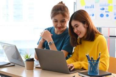 İki genç yaratıcı insan fikirleri paylaşıyor, modern ofiste online bilgi tartışması yapıyorlar..