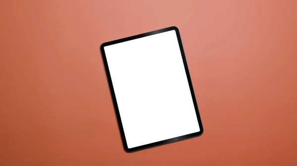 Digitales Tablet mit leerem Bildschirm auf orangefarbenem Hintergrund mit Kopierraum. Draufsicht, flache Lage. — Stockfoto
