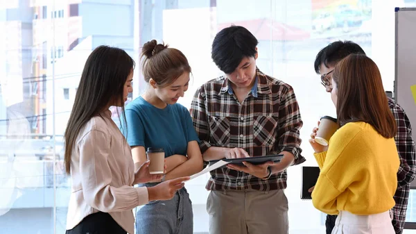 Equipo de jóvenes creativos haciendo una lluvia de ideas y preparando la presentación para clientes o inversores de la empresa. — Foto de Stock