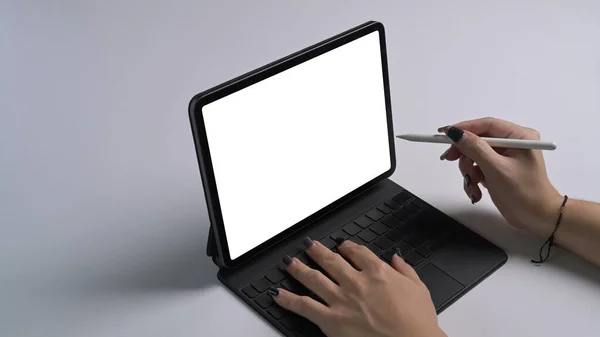 Colpo ritagliato donna che tiene penna stilo puntando sullo schermo del tablet digitale. — Foto Stock