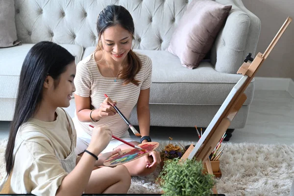 Asian mother with little daughter painting and spending leisure time together at home. — Stock Photo, Image