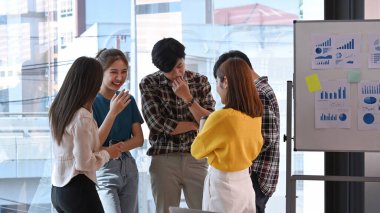 Genç iş adamları beyin fırtınası yapıyor ve yaratıcı ofiste önemli bir proje üzerinde çalışıyorlar..