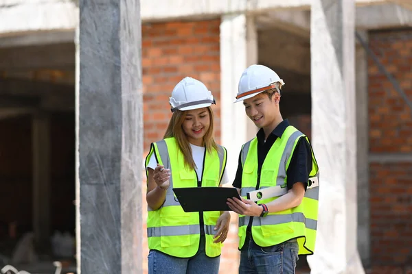 Engineer managers dragen veiligheidsvest en helm werken samen op de bouwplaats — Stockfoto
