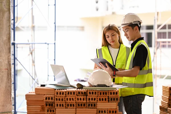 Team van inspecteurs die samen werken en discussiëren over bouwprojecten — Stockfoto