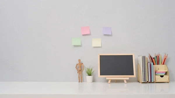 Leeg schoolbord, potplant en briefpapier op witte tafel. Kopieer ruimte voor uw informatie-inhoud. — Stockfoto
