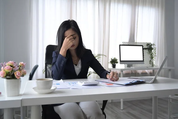 Frustrerad kvinnlig kontorsarbetare ser orolig, trött och överväldigad när du arbetar på kontoret skrivbord. — Stockfoto
