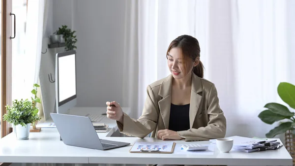 Encantadora joven mujer de negocios sentada en el lugar de trabajo moderno y el uso de ordenador portátil. — Foto de Stock