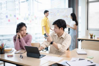 Genç iş adamları fikirleri paylaşıyor, iş stratejisi bilgilerini modern ofiste tartışıyor..