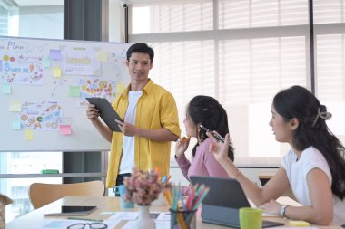 Girişimci işadamları rahat ışık ofisinde yeni bir proje için fikir alışverişinde bulunuyorlar..