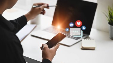 Sosyal medya simgesi içeren akıllı telefon kullanan bir adam. Cep telefonu kavramı üzerine sosyal medya etkileşimleri.