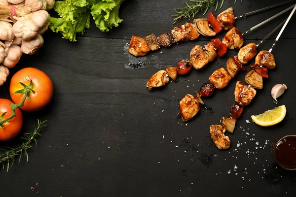 Смачні м'ясні шампури на грилі з помідорами, солодким перцем і цибулею на чорному дерев'яному столі. Вид зверху з пробілом для копіювання — стокове фото