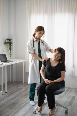 Parlak bir klinikte hastayla tam boy fizyoterapist tedavisi yapıyor..