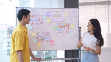 Genç işadamı ve meslektaşları iş planını açıklıyor, toplantıda projeyi ters çizelgede sunuyorlar..