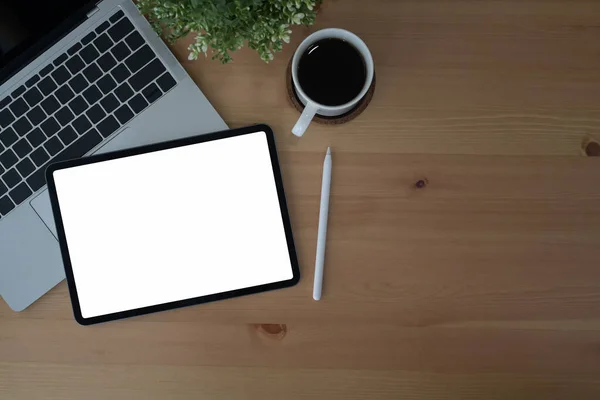 Local de trabalho confortável com tablet digital, computador portátil e xícara de café em fundo de madeira. Vista superior. — Fotografia de Stock