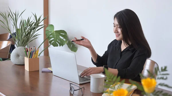 Bizneswoman patrzy na ekran laptopa komputera, ogląda webinarium lub robi czat wideo z kolegami. — Zdjęcie stockowe