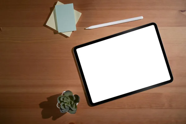 Mock up digital tablet, stylus pen and sticky notes on wooden table. Blank screen for advertise text.