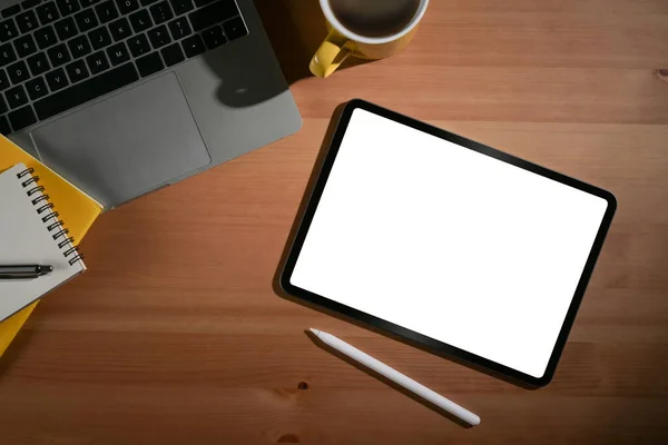 화이트 스크린, 노트북, 커피 컵, 노트북 이 있는 디지탈 태블릿은 목조 사무실 책상에 놓여 있다. 나막신. — 스톡 사진