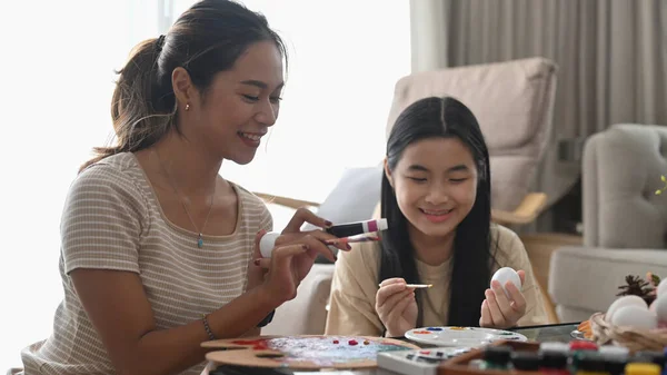행복 한 가족은 밝은 거실에 앉아 부활절 달걀을 함께 색칠 한다. 부활절 연휴와 사람들의 개념. — 스톡 사진
