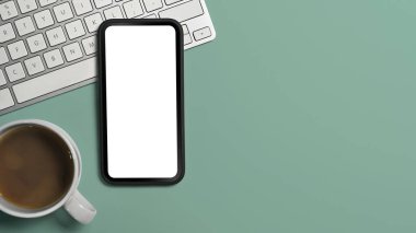 Düz kontak akıllı telefon, kahve fincanı ve yeşil fonda keyoard. Boşluğu kopyala, reklam metni için boş ekran.