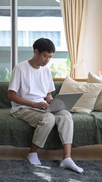 Полнометражный Снимок Молодого Человека Сидящего Светлой Гостиной Ноутбуком — стоковое фото