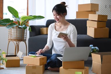 Girişim sahibi internetten siparişleri kontrol etmek için akıllı telefon kullanıyor. Çevrimiçi satış, E-ticaret kavramı.