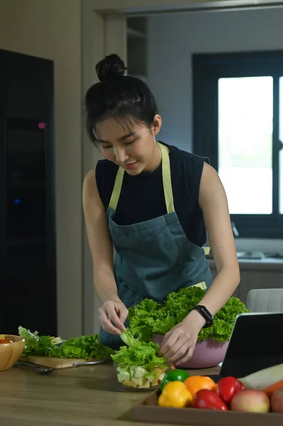 Vegetarian woman preparing healthy vegan food at home kitchen. Healthy food lifestyle concept.
