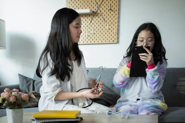 Vreugdevolle Aziatische Meisjes Spelen Als Arts Patiënt Thuis — Stockfoto