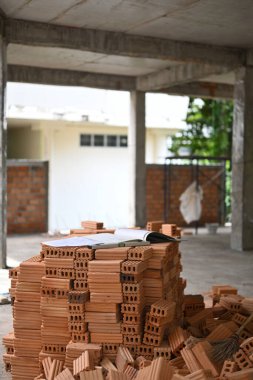 İnşaat alanında yığınla tuğla var. Onarım ve inşaat malzemeleri kavramı.