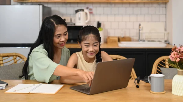 在网上学习网络课程 和妈妈一起在厨房做作业的亚洲小女孩笑着 电子学习教育概念 — 图库照片