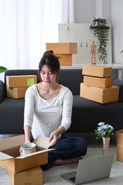 Küçük işletme girişimcisi kargo için paket kutuları topluyor.