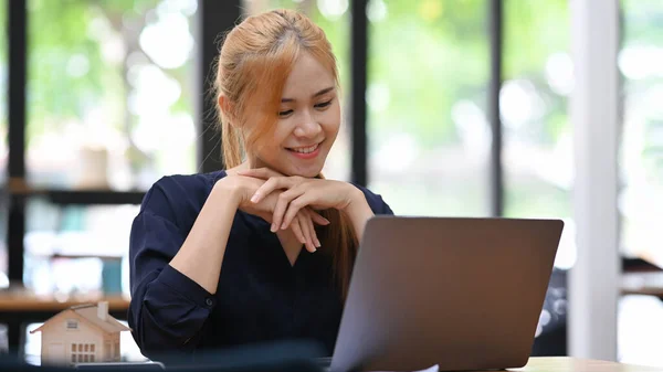 かなり若い女性は彼女のラップトップコンピュータ上でオンラインウェビナーを見て — ストック写真