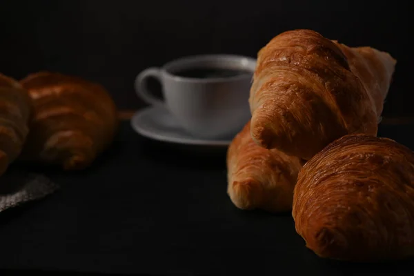 Frisch Gebackenes Croissant Und Eine Tasse Kaffee Auf Einem Schwarzen — Stockfoto