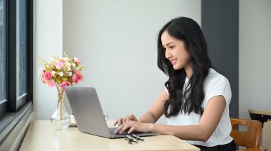 İnternette çalışan çekici Asyalı kadın dizüstü bilgisayardan internetten Webinar izliyor..