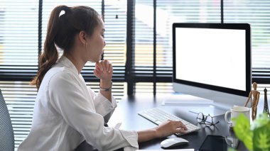 Konsantre Asyalı iş kadını iş e-postalarını okuyor, iş yerinde online web sitesi izliyor..