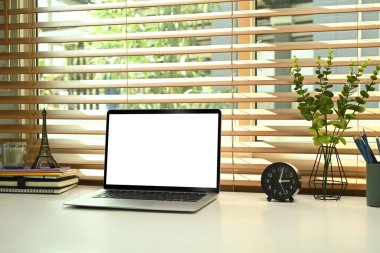 Beyaz masadaki boş ekranlı dizüstü bilgisayar. Merkez ofis masası.