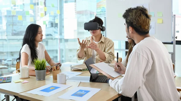 Businessman wearing virtual reality headset at business meeting. Teamwork, startup, innovation concept.